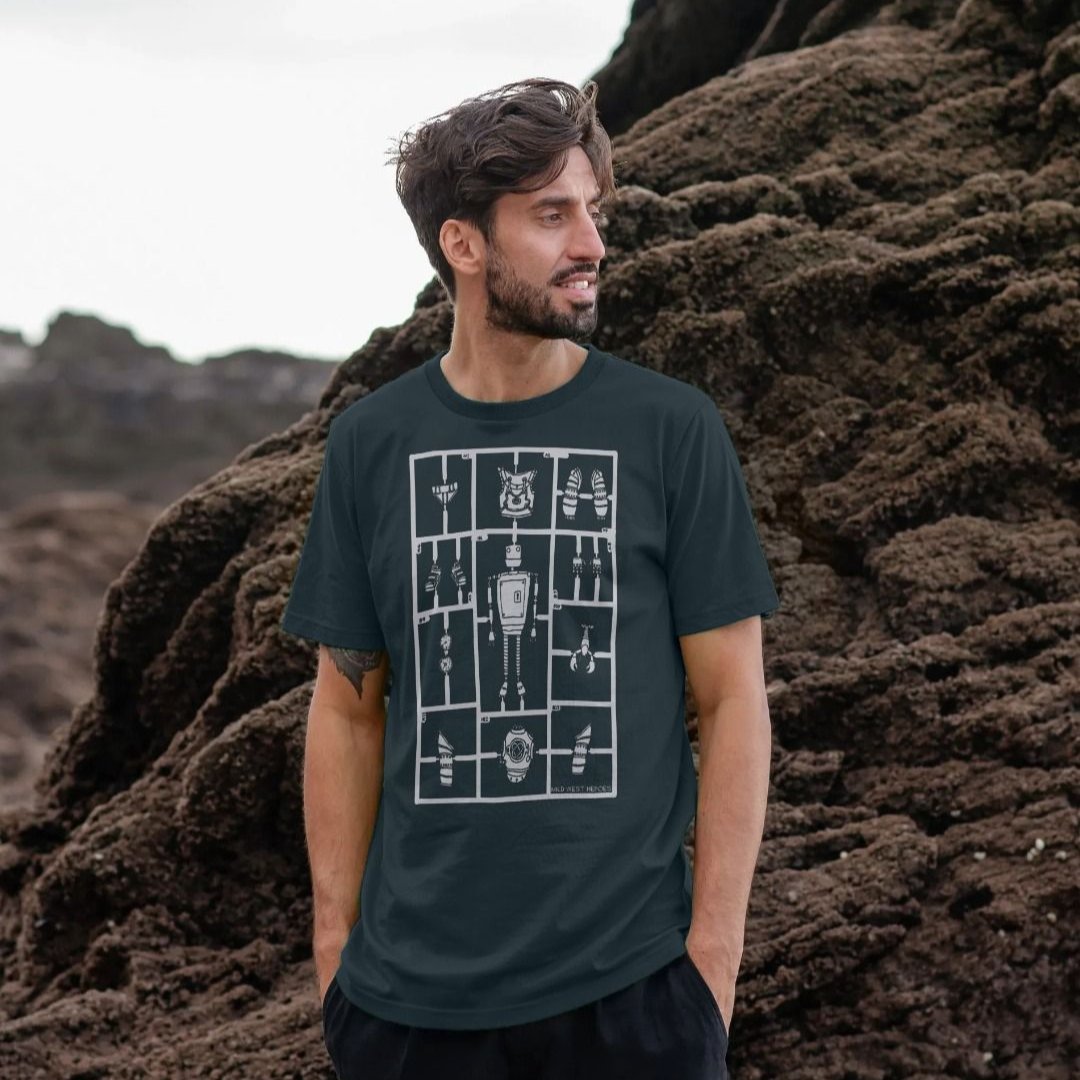 Man standing against rocks wearing a Denim Blue Airfix Robot organic cotton t-shirt